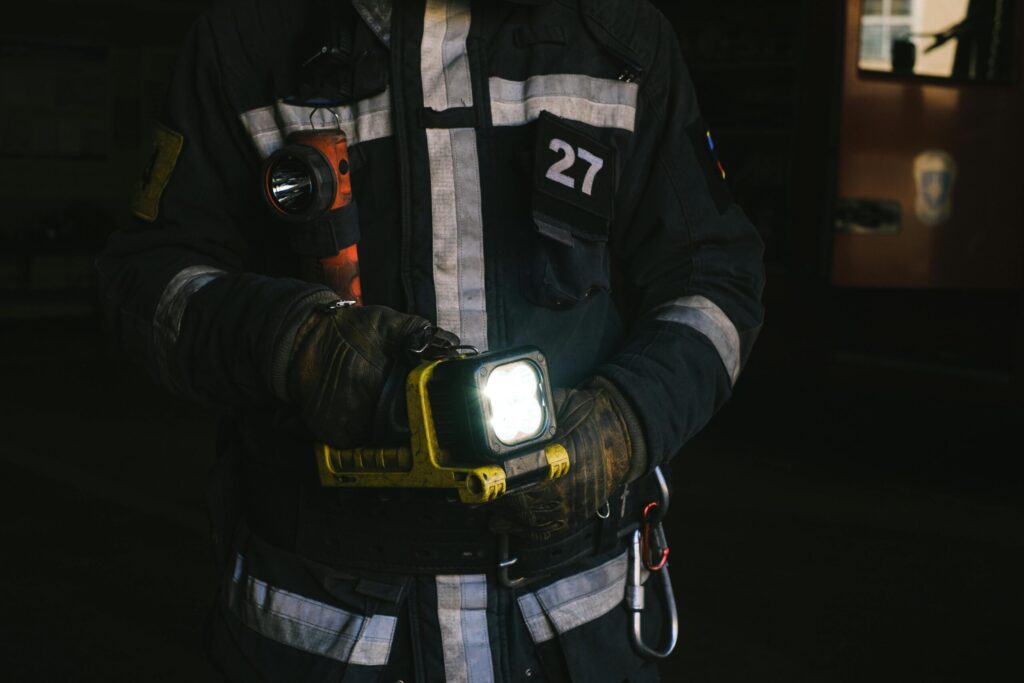 Firefighter in full protective clothing holding a lantern, showcasing emergency preparedness.